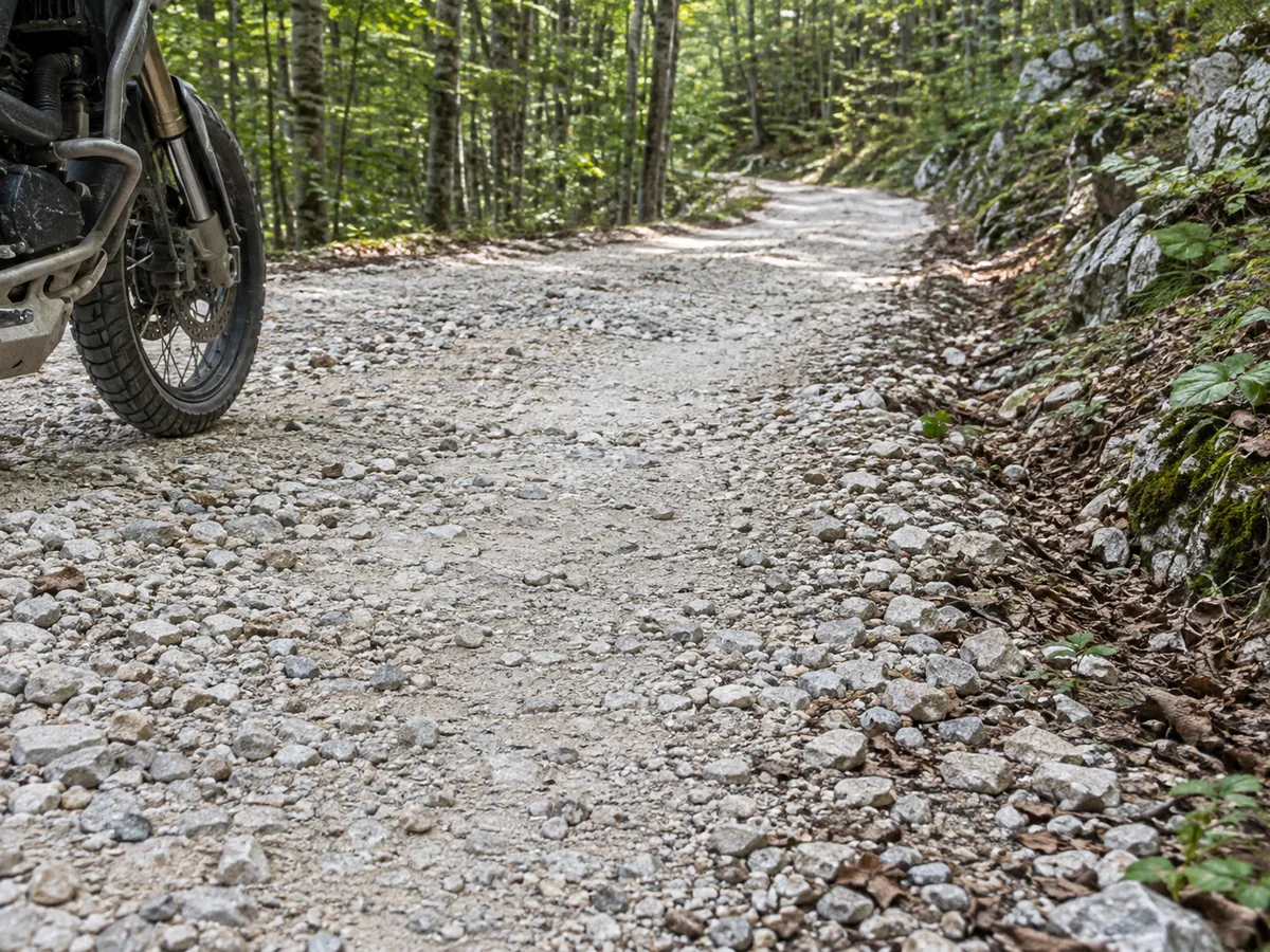Pale compacted gravel and loose limestone illustrate changing traction on the unpaved middle section.